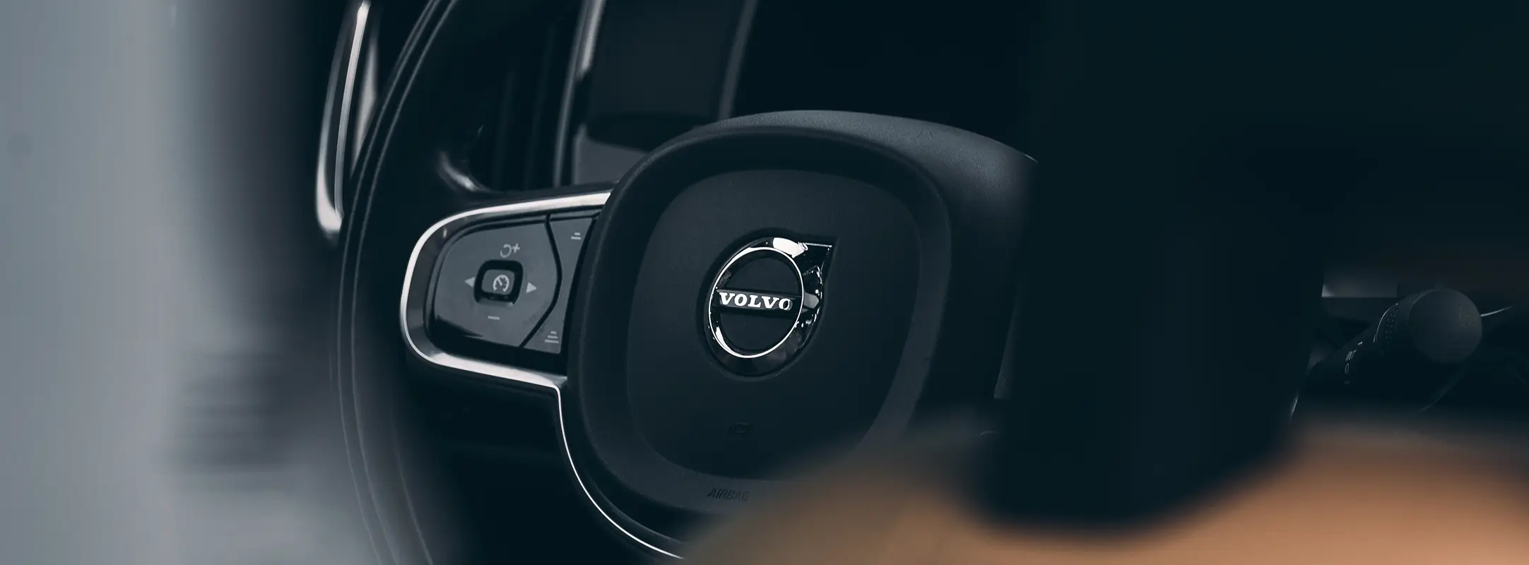 Zwart leren stuur van een Volvo met het logo erop