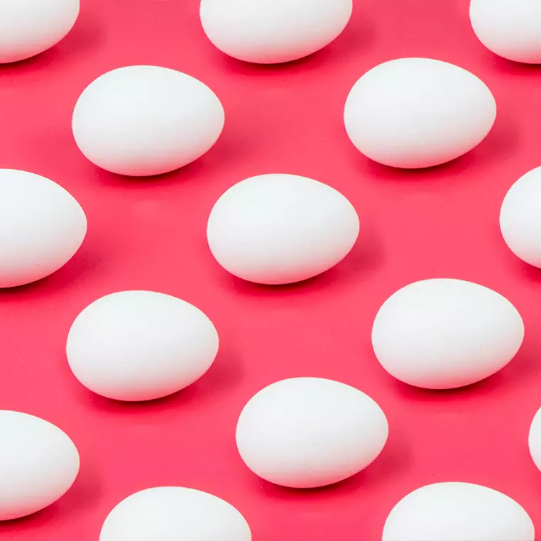 Verschillende eieren op een roze achtergrond