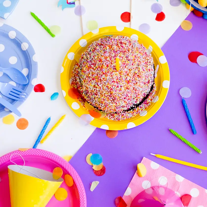 Cadeaus, taart en confetti op een verjaardagstafel