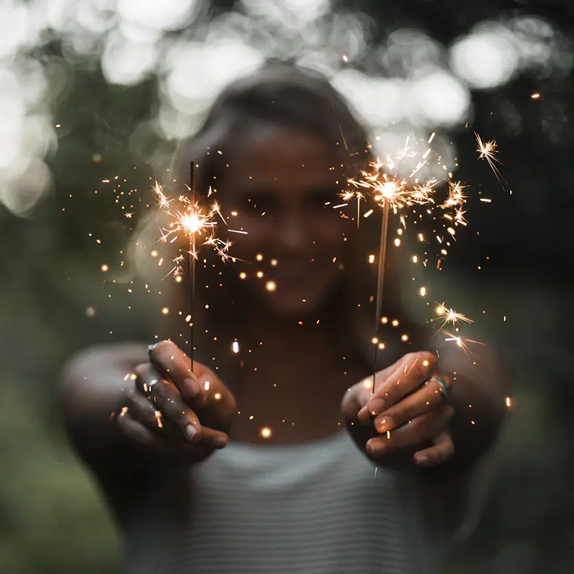 Vrouw met twee fonkelende sterretjes in haar handen