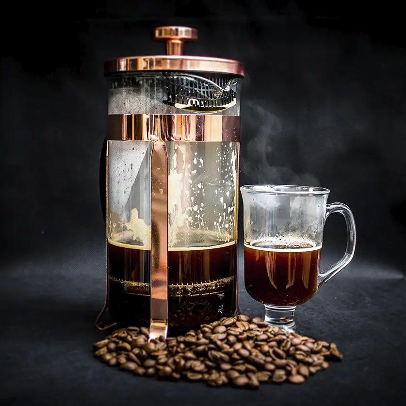 Cafetière met koffie en een kopje koffie met koffiebonen