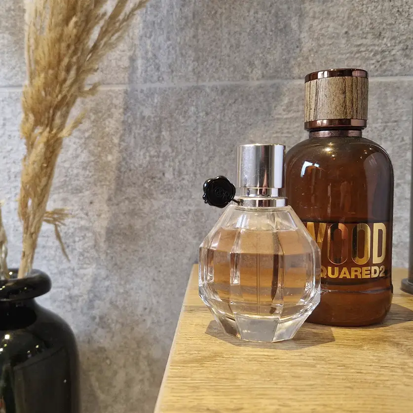 Mannen en vrouwen parfum op tafel met vaas met decoratie