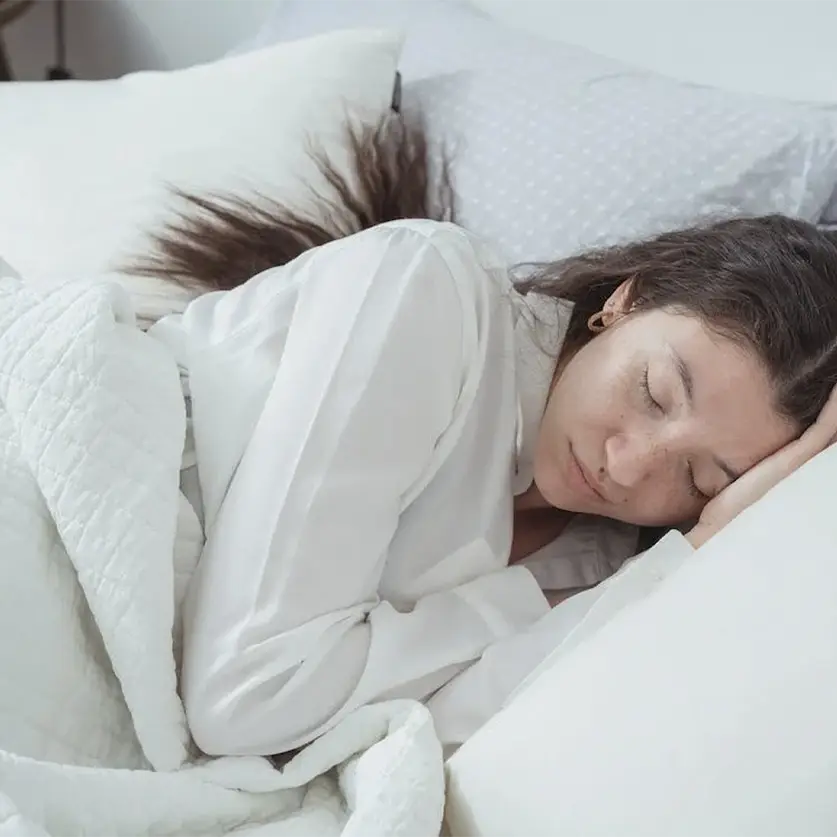 Vrouw die in haar bed ligt te slapen