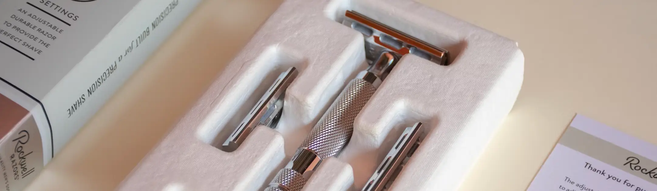 Een scheermes abonnement op tafel met twee losse mesjes en een houder