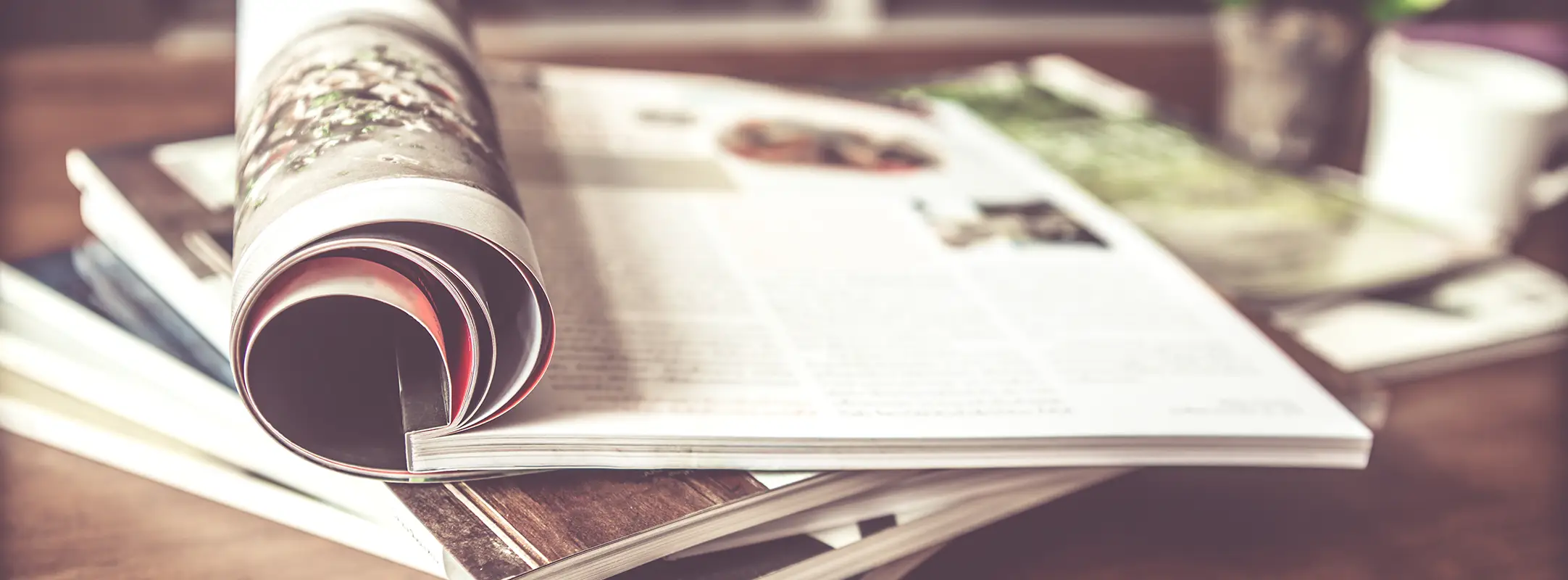 Fysiek tijdschrift via een tijdschrift abonnement gekregen op een tafel met omgeslagen pagina.