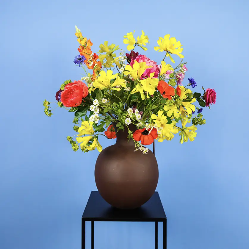 Mooie kunstbloemen in bruine vaas