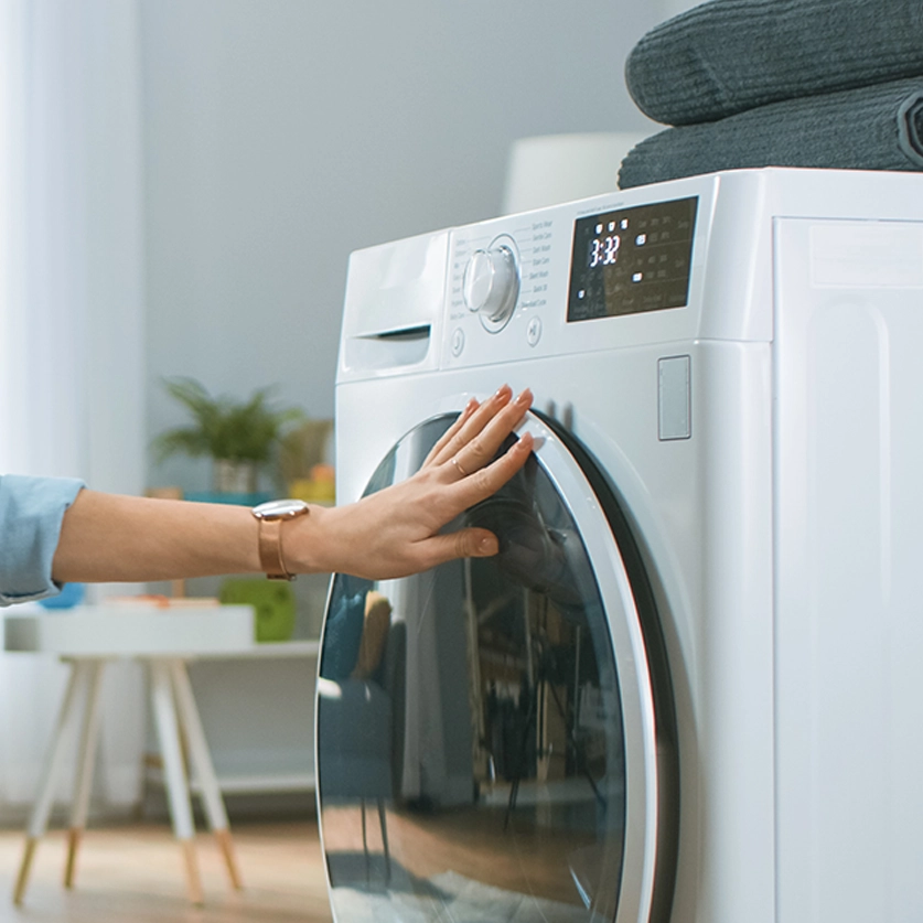Hand op een wasmachine