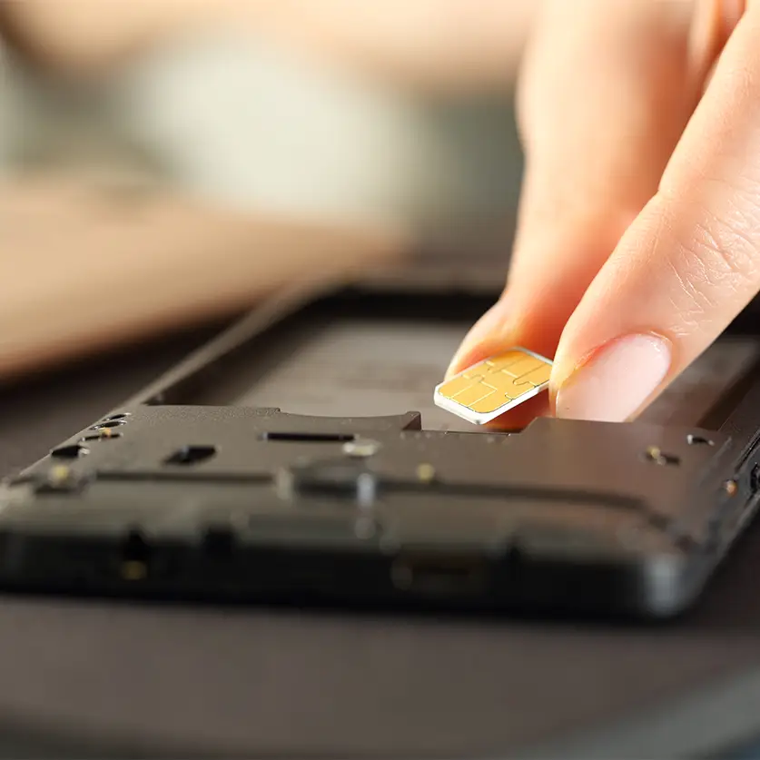 Telefoon die op zijn kop ligt, zonder accu waarin iemand zijn sim kaart stopt.