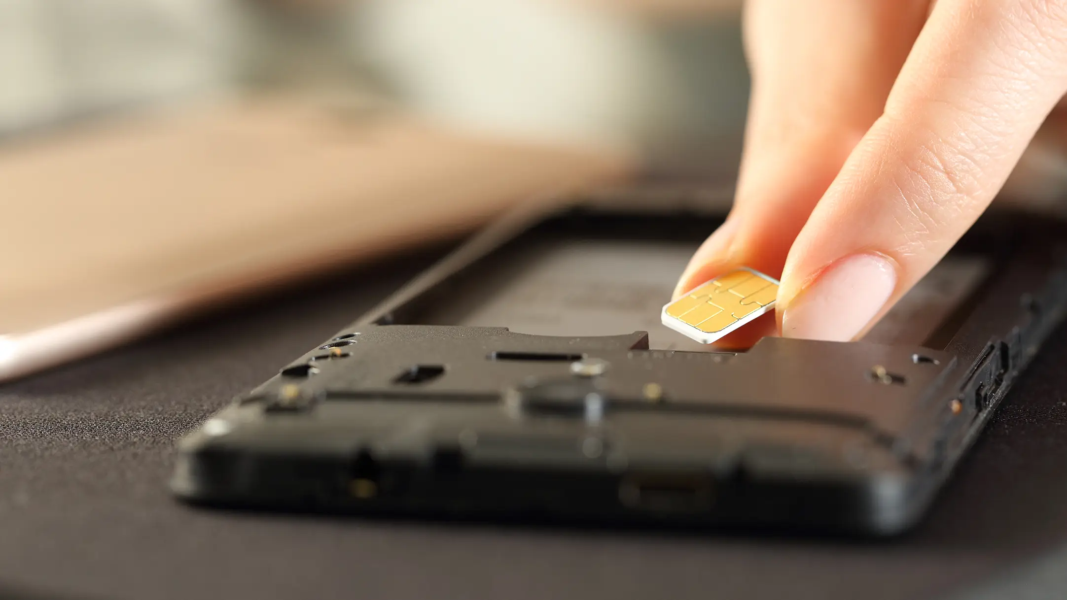 Telefoon die op zijn kop ligt, zonder accu waarin iemand zijn sim kaart stopt.